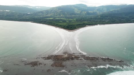 whale tail peninsula beach in costa rica at high tide on cloudy day