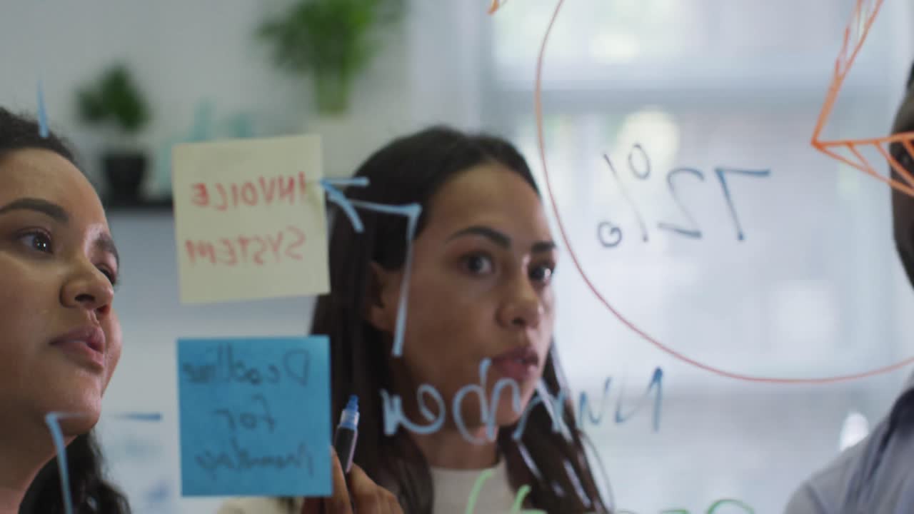 Focused diverse group of business people working together, brainstorming in modern office