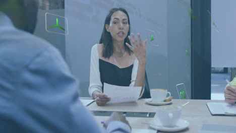 Animation-of-multiple-icons-over-diverse-female-coworkers-discussing-reports-with-coworkers