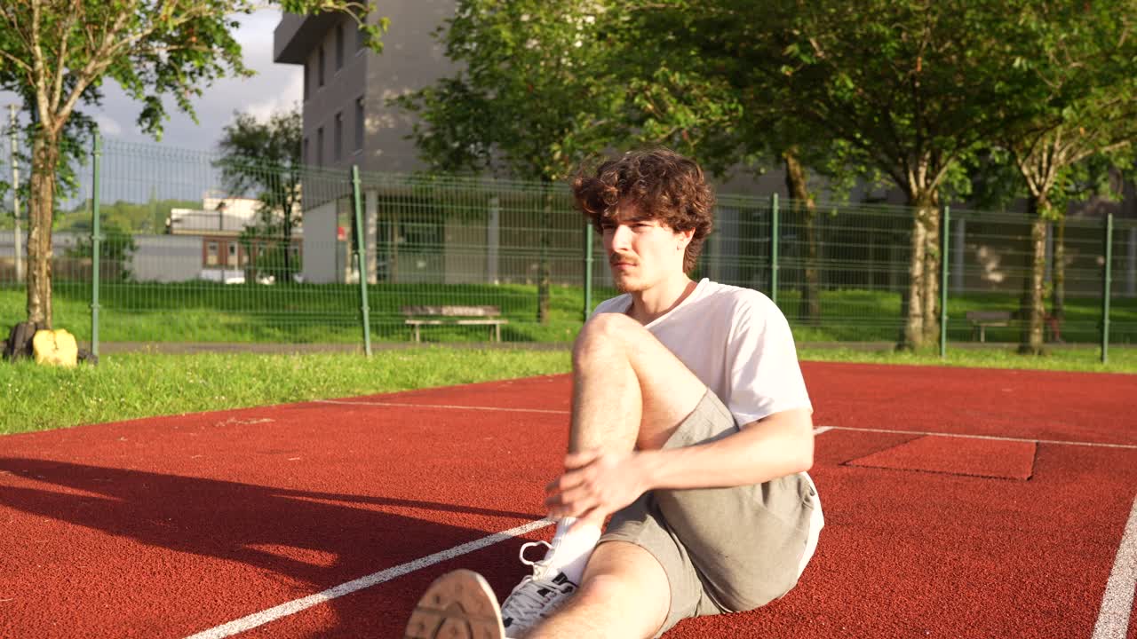 Man stretching on sports ground