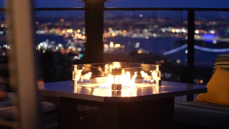 fire place that overlooks the city lights and lions gate bridge in vancouver, canada