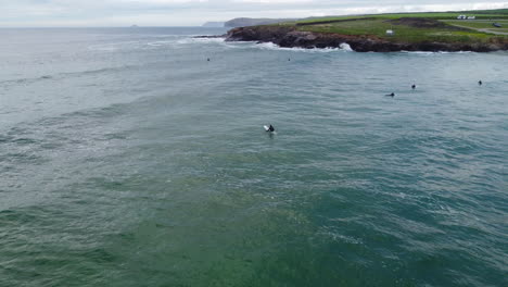 surfers enjoying the rough seas of the cornwall coast at harlyn bay