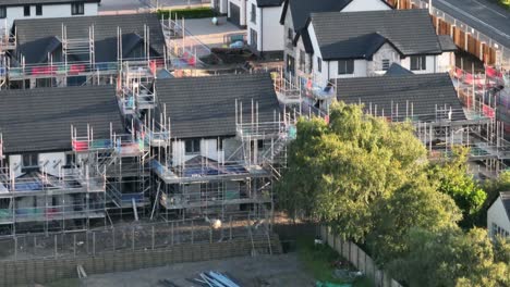 establishing shot showing multiple houses undergoing construction in a building site