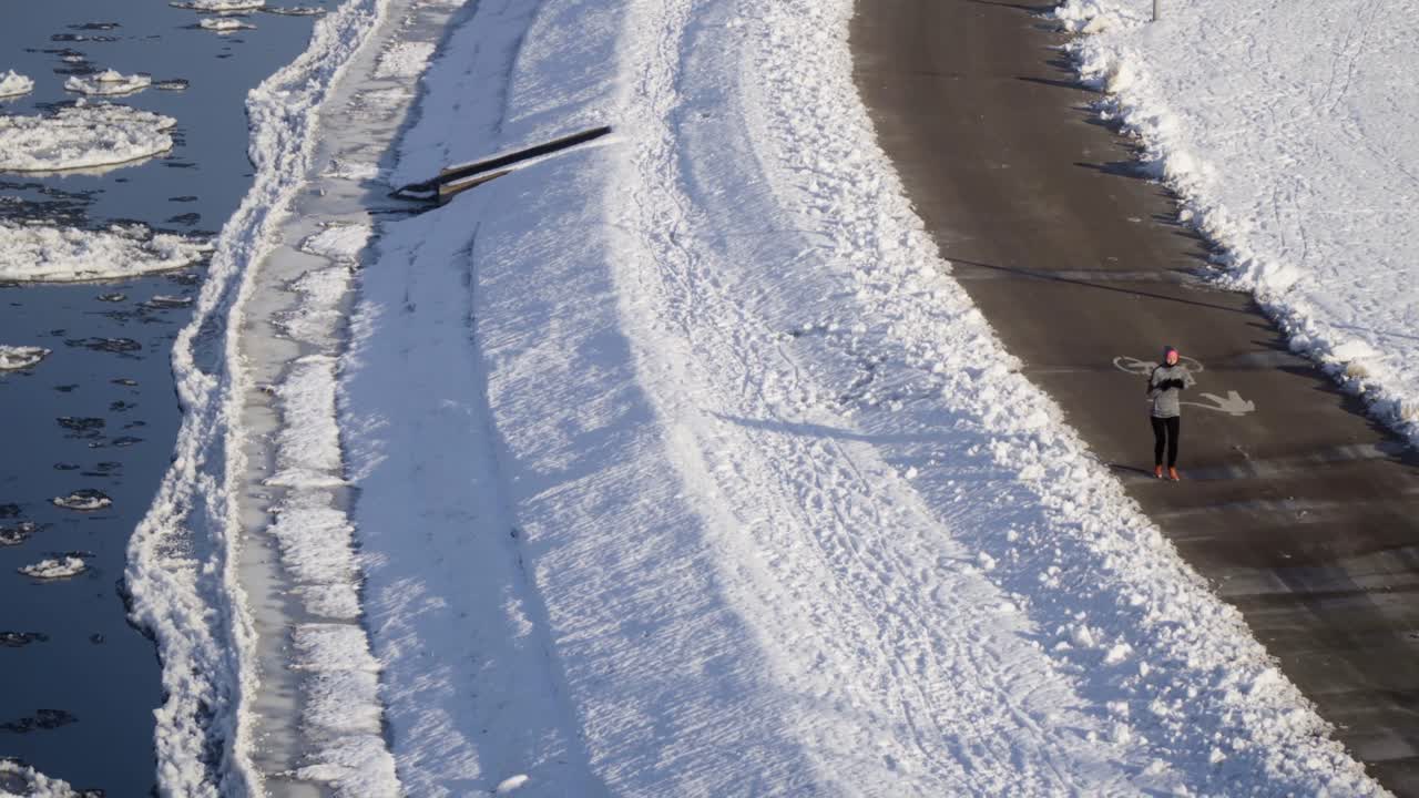 mujer trotando corre junto al río congelado con témpanos de hielo durante el invierno-1