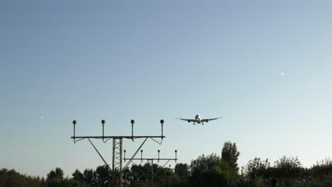 Gimbal-shot-of-airplane-approaching-airport-on-sunny-day,-preparing-to-land