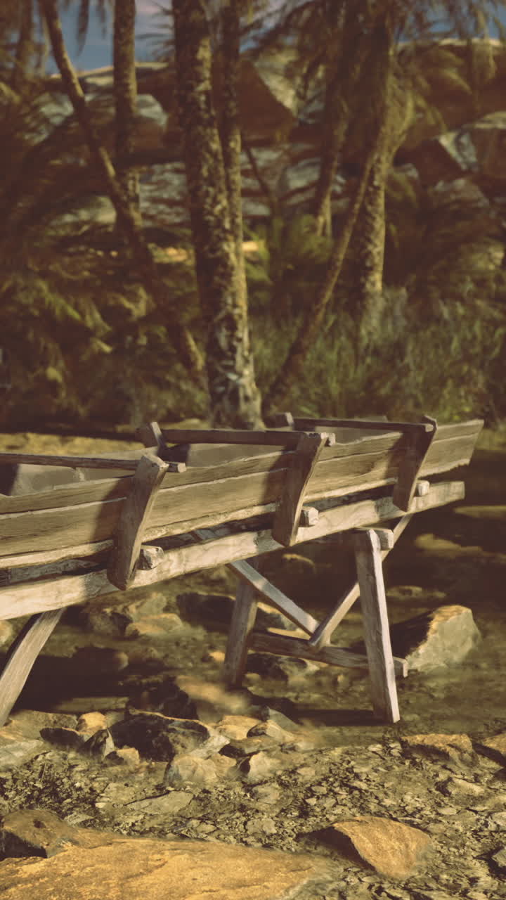Old wooden boat rests by calm water surrounded by trees and rocks