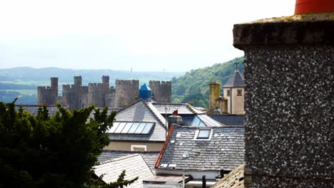 Residential-homes-rooftops-inside-Conwy-castle-townscape-stone-rampart-walls-dolly-left-reveal-chimney