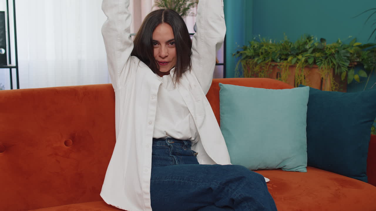 mujer joven feliz mirando con aprobación a la cámara mostrando los pulgares hacia arriba, como un signo positivo, buenas noticias