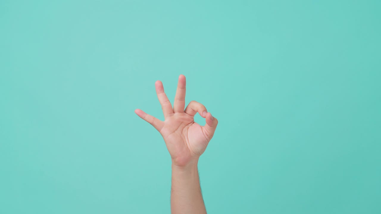 인간 손을 들어 올리고, 손의 몸짓을 ok 표시 또는 반지 몸짓, 엄지손가락과 지표손가락을 원으로, 그리고 다른 손가락을 똑바로 들고 있는 근접 촬영.