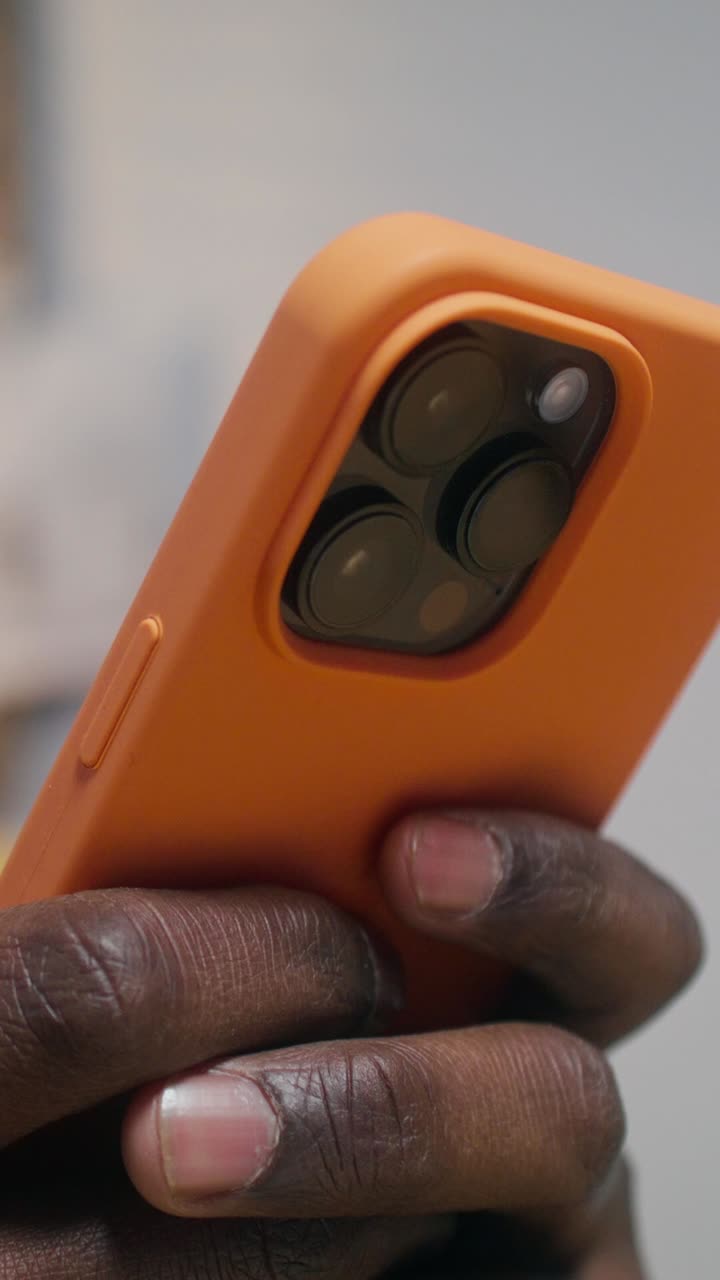 오렌지색 아이폰 케이스를 들고 있는 사람