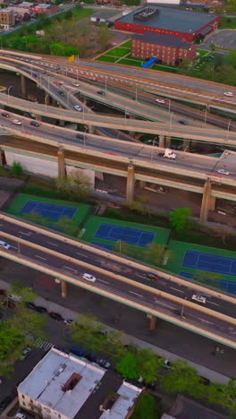 low houses of new york and numerous parking lots. complicated traffic system with cars moving on. aerial perspective. vertical video