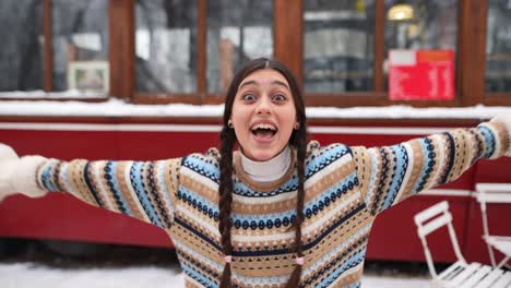 woman enjoying snow day in front of a red bus