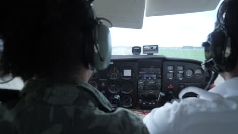 una toma en cámara lenta de un piloto uniformado y un copiloto despegando