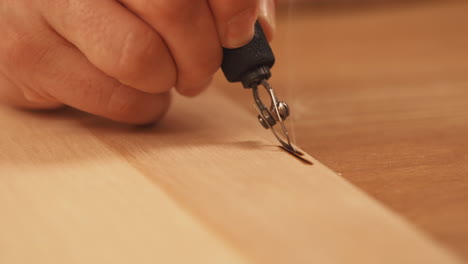 Close-up-footage-of-artist-woodburning-with-wisp-of-smoke-releasing-from-wood-burn