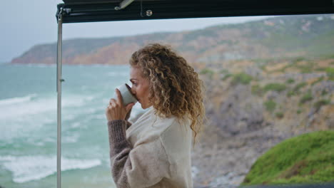 lady drinking tea sea coast enjoying happy marine vacation close up. curly woman