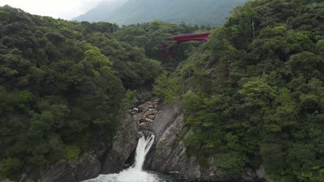 torokino falls in yakushima, tilt up reveal of misty mountain in japan