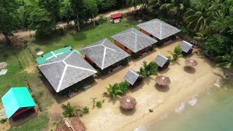 Toma-Cinematográfica,-Vista-Aérea-Ascendente-De-Drones-De-Un-Resort-En-La-Costa,-Playa-De-Arena-Blanca,-Bungalows-En-Roxas,-Palawan