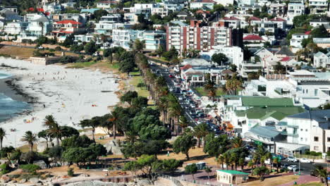 Destino-De-Vacaciones-De-Verano.-Edificios-En-Un-Complejo-Turístico-Tropical-Y-Gente-En-La-Playa-De-Arena-En-La-Bahía-De-Campamentos.-Clima-Ventoso-En-Un-Día-Soleado.-Ciudad-Del-Cabo,-Sudáfrica