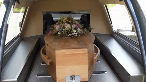 closeup shot of a funeral casket in a hearse or chapel or burial at cemetery