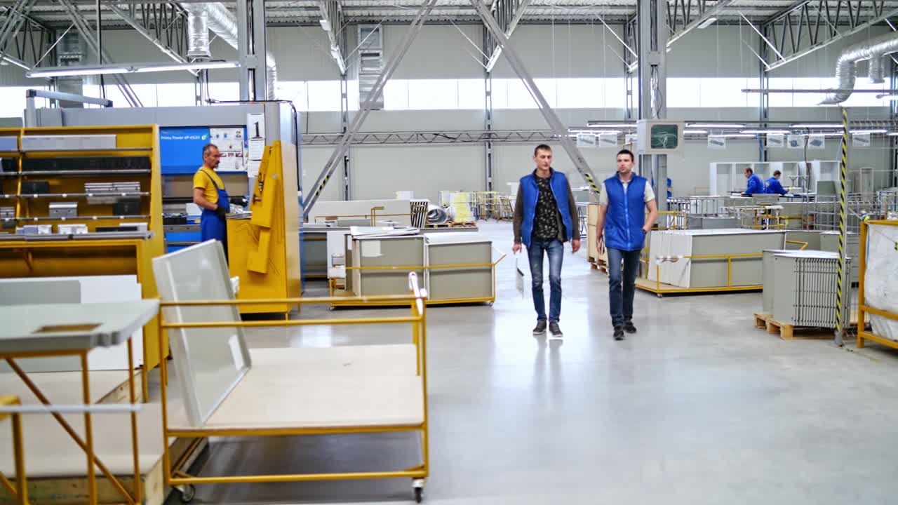 Group of people in industrial production. Workers assembling and constructing in modern industrial factory