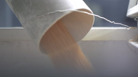 튜브에서 포장 기계로 떨어지는 옥수수 곡물