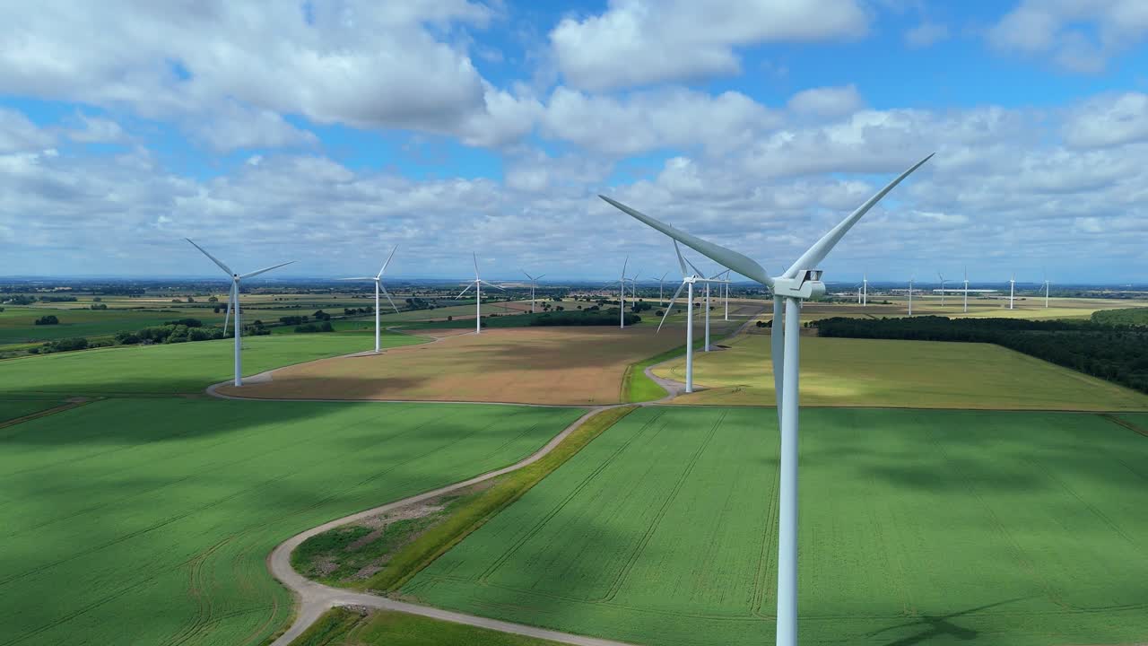 Cinematic aerial footage of wind turbine energy generation over rolling English hills
