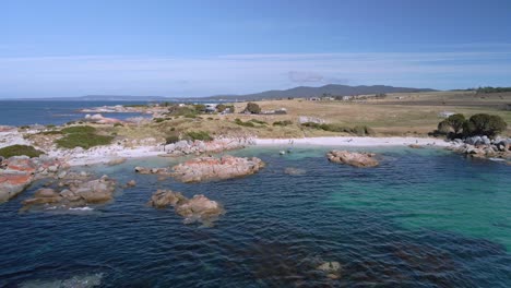 wide aerial reveal of bay of fires coastline with granite rocks and turquoise ocean, tasmania, australia