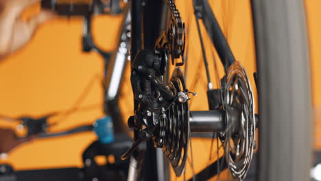 Close-up-shot-of-bicycle-wheel-mechanism-being-examined-by-woman