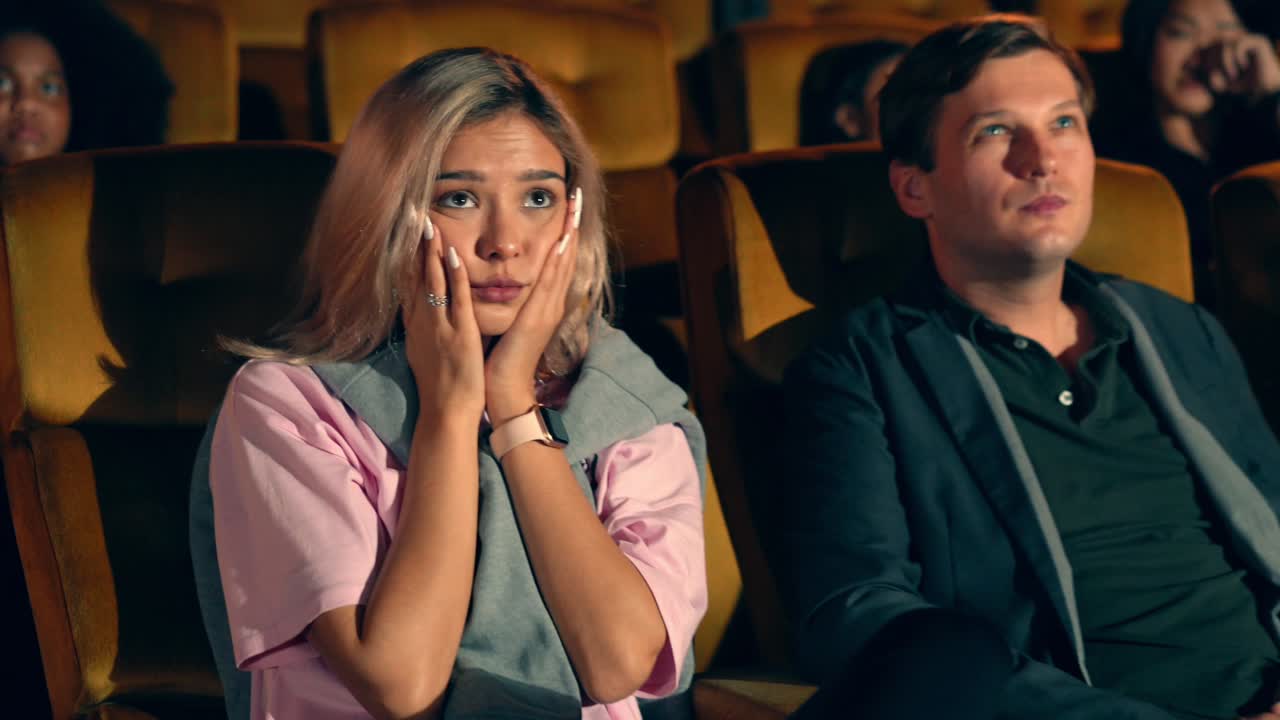 pessoas assistindo a um filme no cinema.