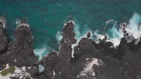 Aqua-blue-ocean-set-against-black-lava-rocks
