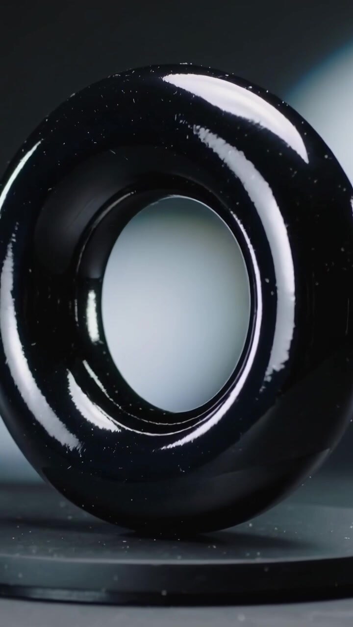 Vertikal video: Drejeskive begynder at rotere en poleret sort torus i et studie, der viser finish