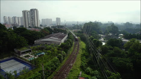 aerial view of a train moving through the parque villa lobos favela in sao paulo, brazil