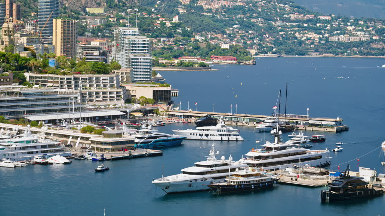 Vista delle barche ormeggiate nel porto turistico di Monaco con lo skyline della città sullo sfondo