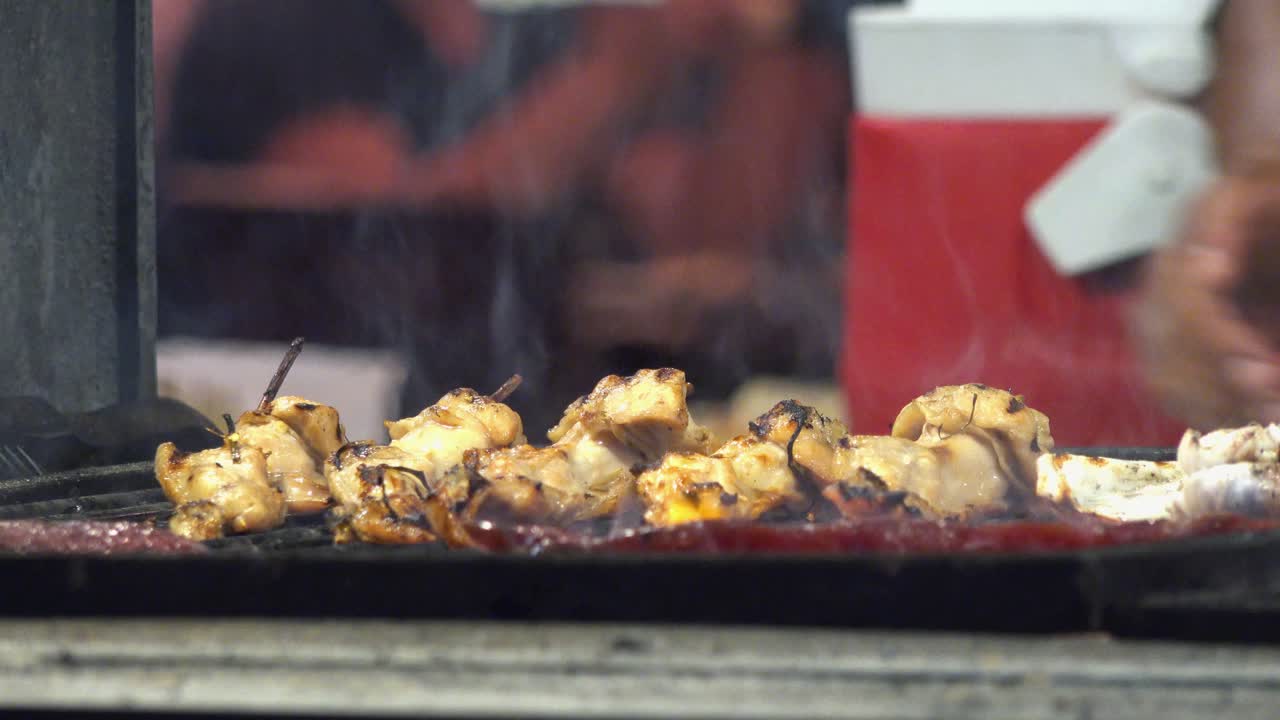 Meat Cooking on Grill While Chef Puts on Two More Pieces