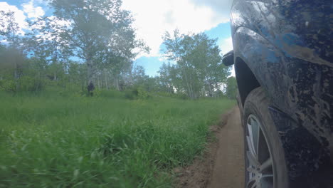 suv off-roading at high speed drives through a creek in the mountains