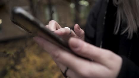 woman using a smartphone outdoors in autumn