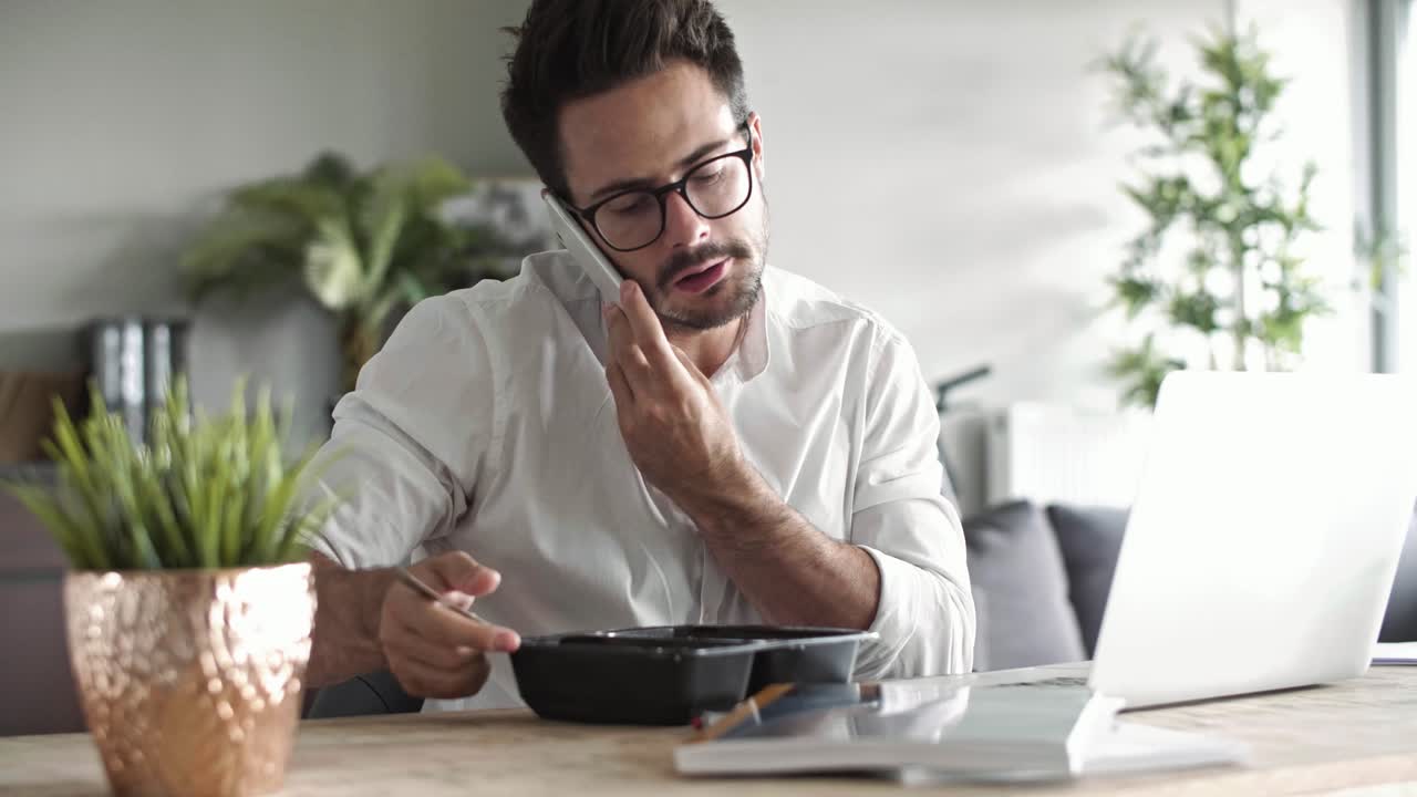 Uomo d'affari multitasking che lavora nel suo ufficio di casa