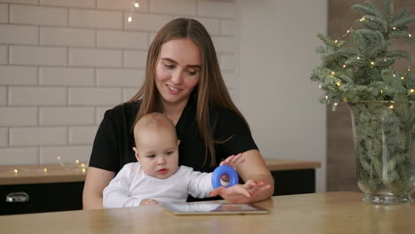 mother-and-baby-are-looking-to-play-and-read-tablet-computer-on-the-couch-at-home