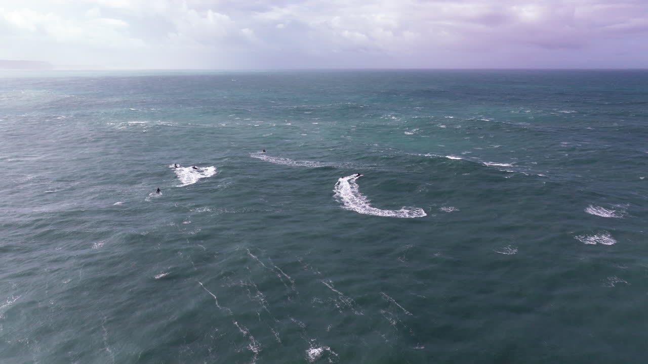 Jet ski pathfinding through giant Nazaré swells, aerial drone view