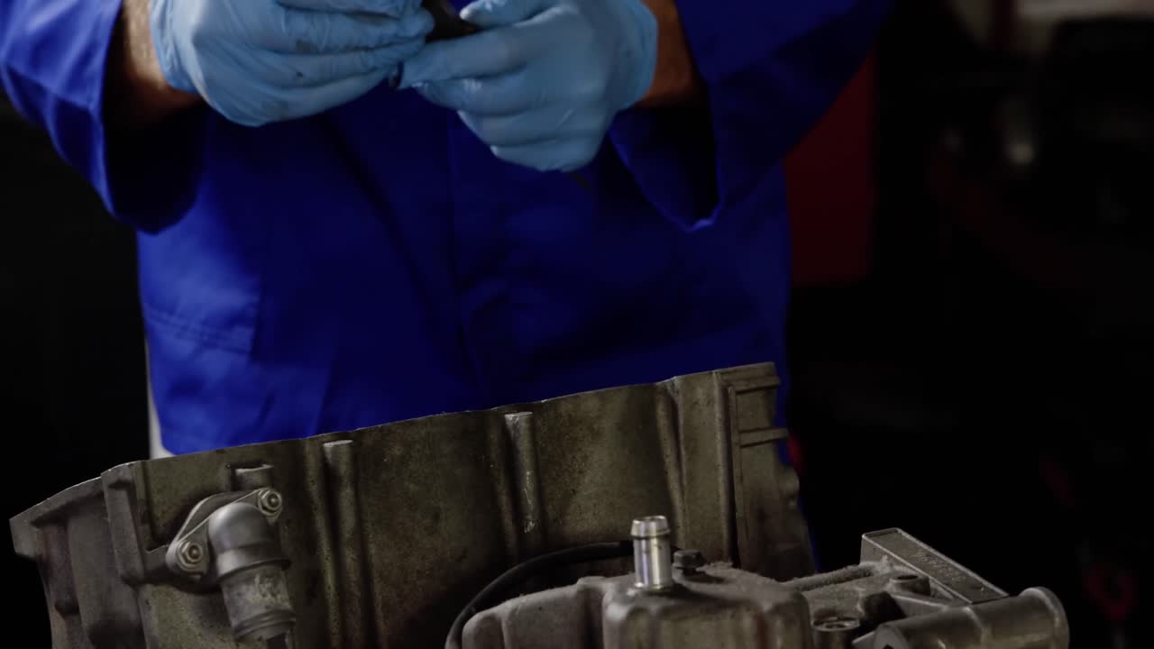 mecánico masculino reparando el motor de una motocicleta en un garaje de reparación 4k