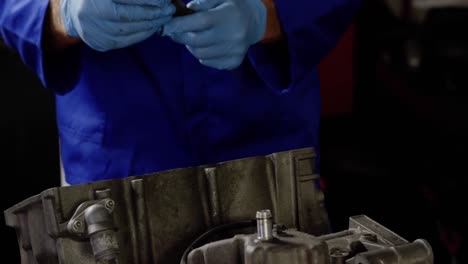 mecánico masculino reparando el motor de una motocicleta en un garaje de reparación 4k