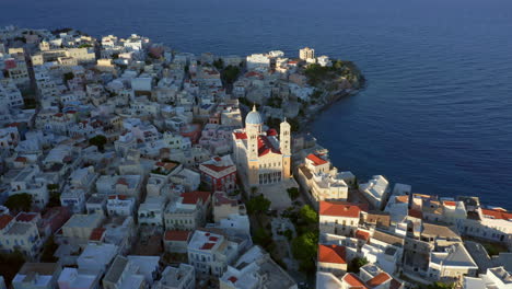 tomada de un avión no tripulado de órbita lenta de la iglesia de san nicolás en ermoupoli de la isla de siros, grecia durante la hora dorada