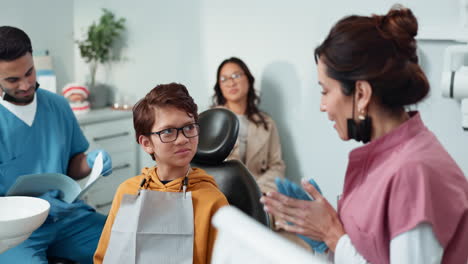 un niño sonriendo a su dentista después de un chequeo exitoso