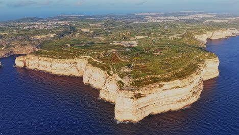 aerial view of malta's coastal landscape and rugged cliffs at sunset
