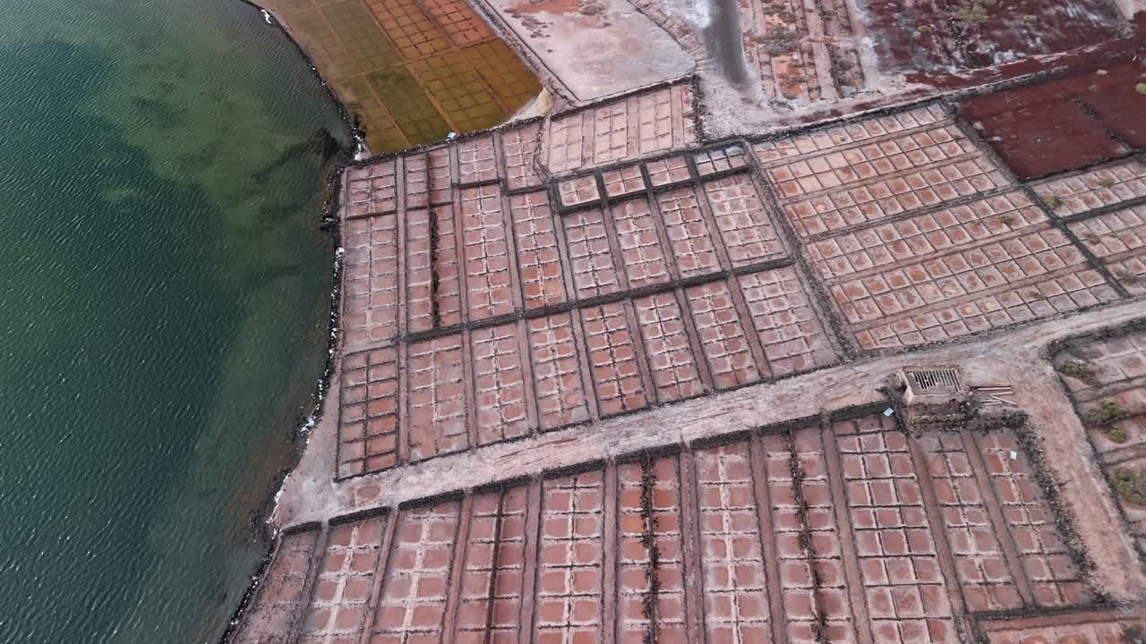 Beautiful aerial drone footage of the Salinas de Janubio salt flats at sunset in Lanzarote, Canary Islands, Spain.