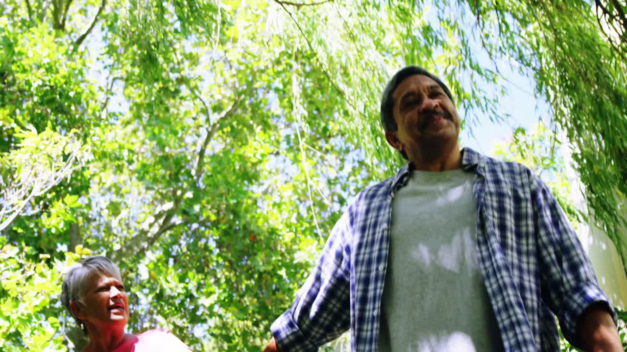 pareja de ancianos tomados de la mano mientras caminan