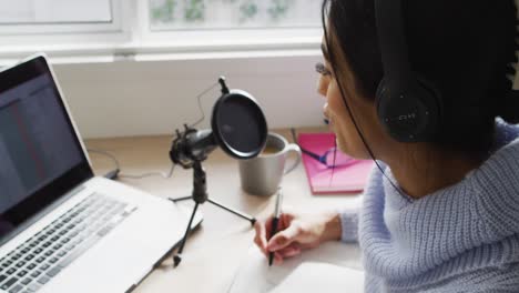 video de una mujer biracial participando en una entrevista en línea en una computadora portátil en casa