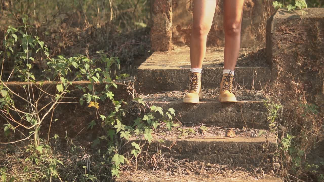 imágenes de las piernas y botas de una niña parada en una escalera.