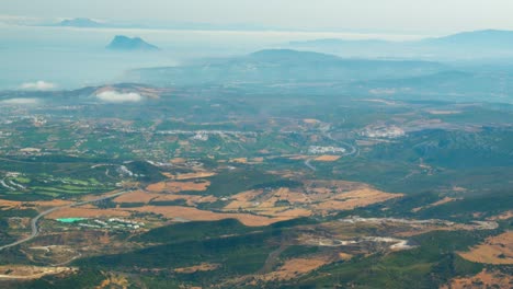 Wolken-Strömen-über-Einem-Kleinen-Ländlichen-Gebiet-An-Der-Küste-Spaniens,-Zeitrafferansicht-Vom-Berggipfel