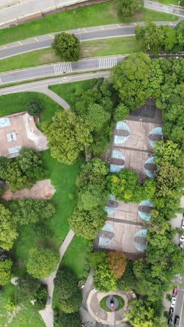 a drone top-view spin shot over owl’s head park in brooklyn, capturing the park's greenery and surrounding urban streets in a smooth circular motion